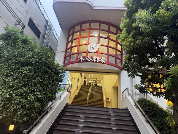 夜晚同一個角度拍攝的本多劇場入口，弧形外牆被燈光照成黃色