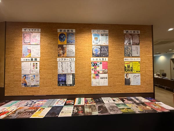 本多劇場大廳內一面貼滿當期演出傳單的牆，按場地分欄排列