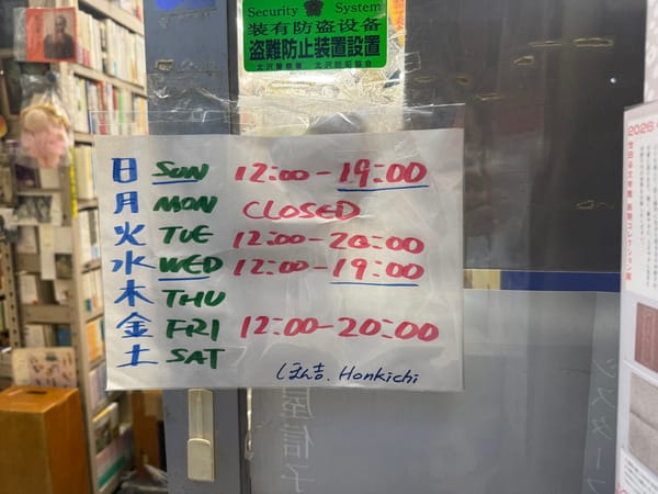 ほん吉玻璃門上手寫的每日營業時間表，用三種顏色的麥克筆寫成