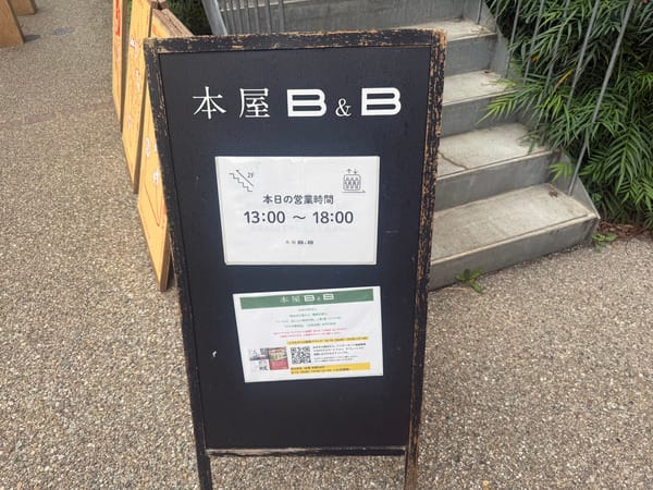 本屋 B&B 門口的黑板立牌，寫著當日營業時間 13:00 到 18:00