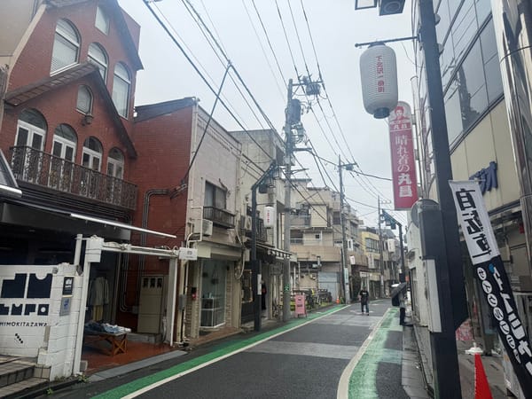 下北澤一番街，兩側是小型店面，路中央漆有綠色自行車道