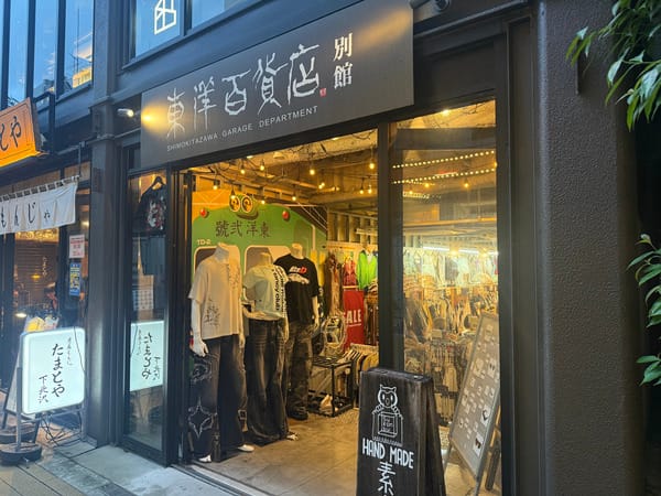 夜晚 Mikan 下北內東洋百貨店別館的亮燈店面，玻璃後方可見衣架